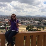 a young woman poses in front of city view